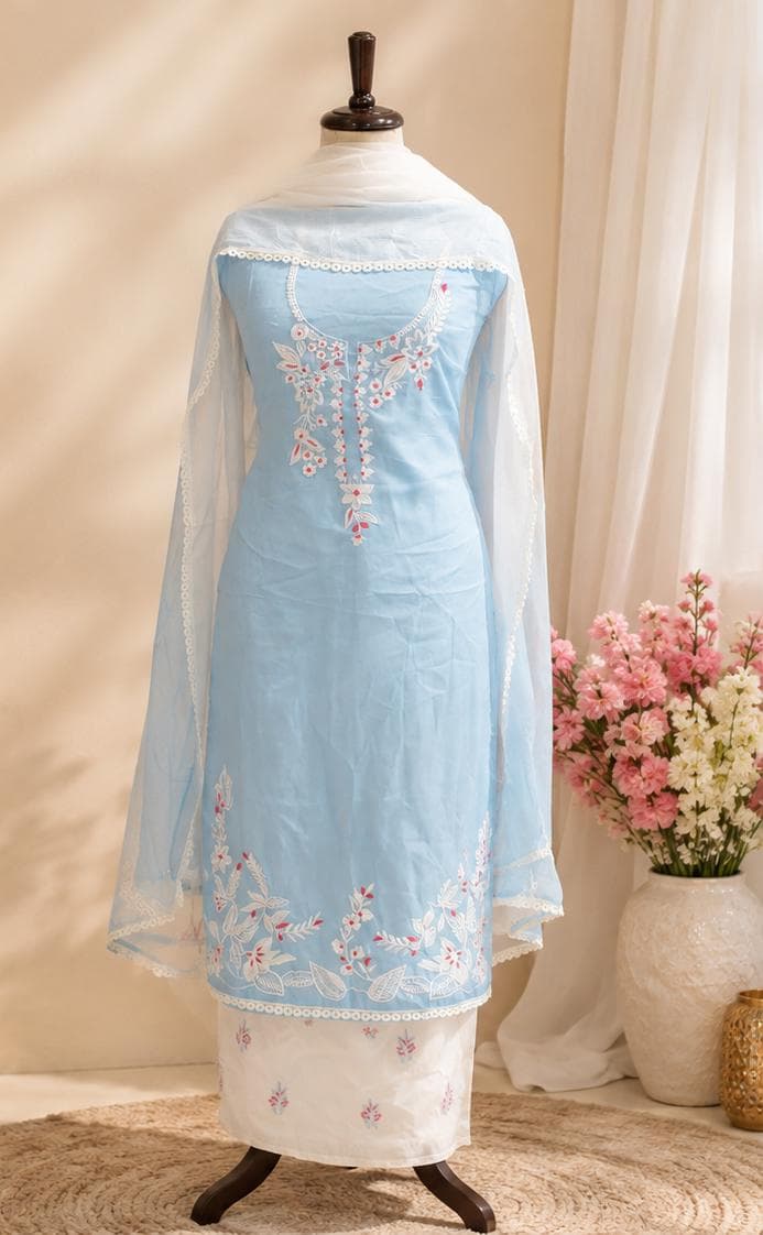 A powder-blue kameez with white floral thread embroidery at the neckline and hem, with a sheer white net dupatta and an ivory floral-printed bottom